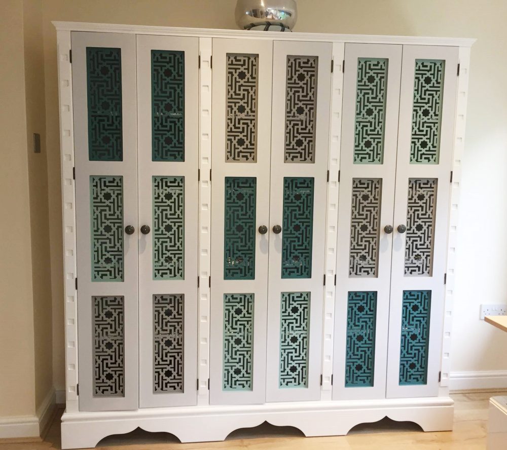 Three sectioned cupboard with vari-toned fretwork door panels