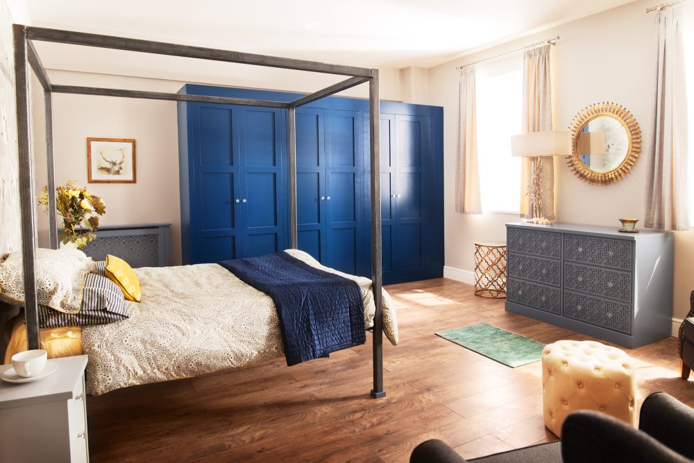 Bedroom featuring a Grey Radiator Cover and Soft Close Drawers Alongside a Bold Blue Wardrobe